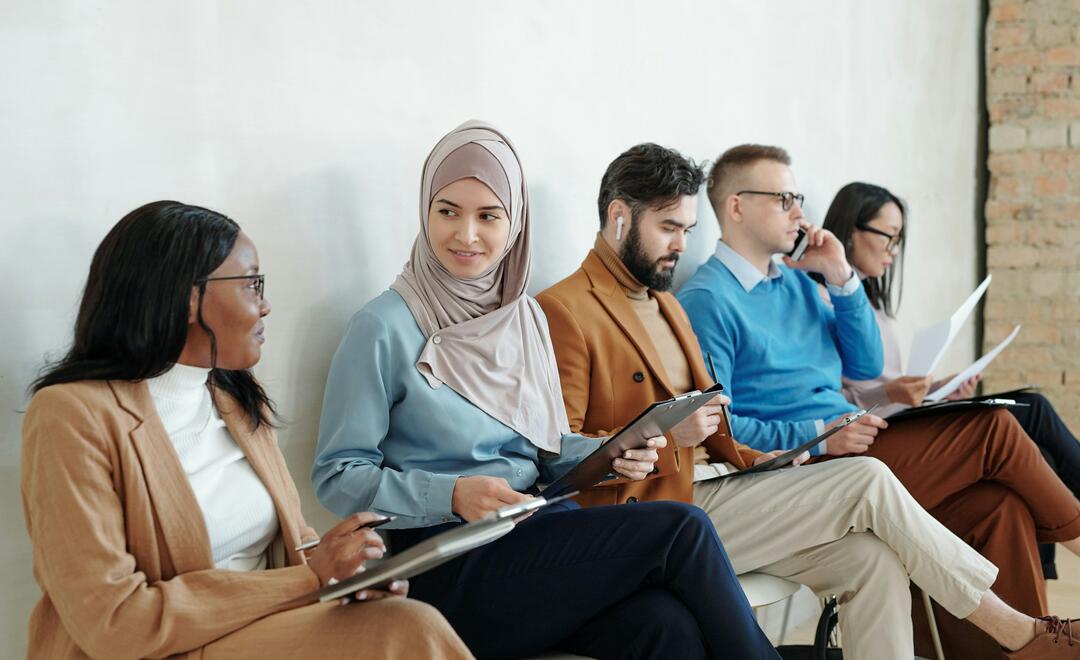 Multiethnische Personengruppe auf Stühlen sitzend