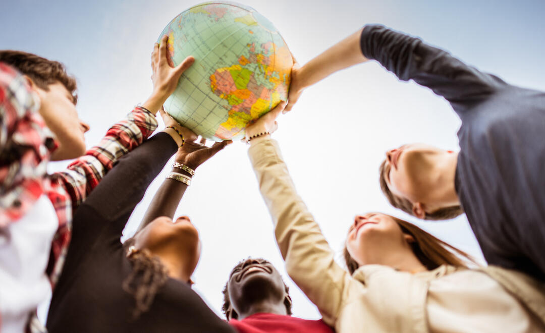 Hände halten einen Globus hoch (Foto: iStock.de/franckreporter)