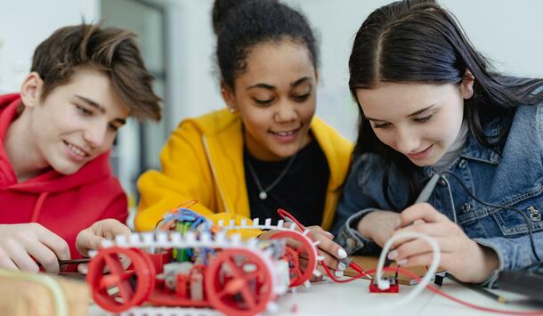Schülergruppe bauen im Technikunterricht ein Fahrzeug 
