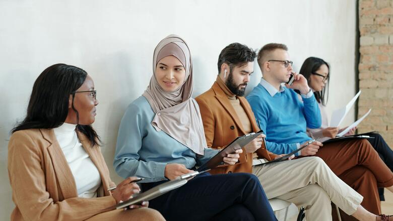 Multiethnische Personengruppe auf Stühlen sitzend